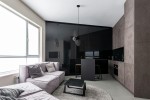 Czarna lampa wisząca Fermi D45 z jedną oprawą G9, umieszczona w nowoczesnym wnętrzu. Lampa zwisa z sufitu nad czarnym stołem, w otoczeniu szarej sofy i minimalistycznego wystroju. W tle widać ciemną zabudowę kuchenną.