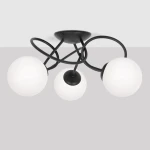 Lampa sufitowa Nela z trzema oprawami E14, w kolorze czarnym i białym. Posiada okrągłe, matowe klosze z białego szkła, zamontowane na czarnych, zakrzywionych ramionach. Ujęcie z dołu, pokazujące detale konstrukcji i rozmieszczenie kloszy.