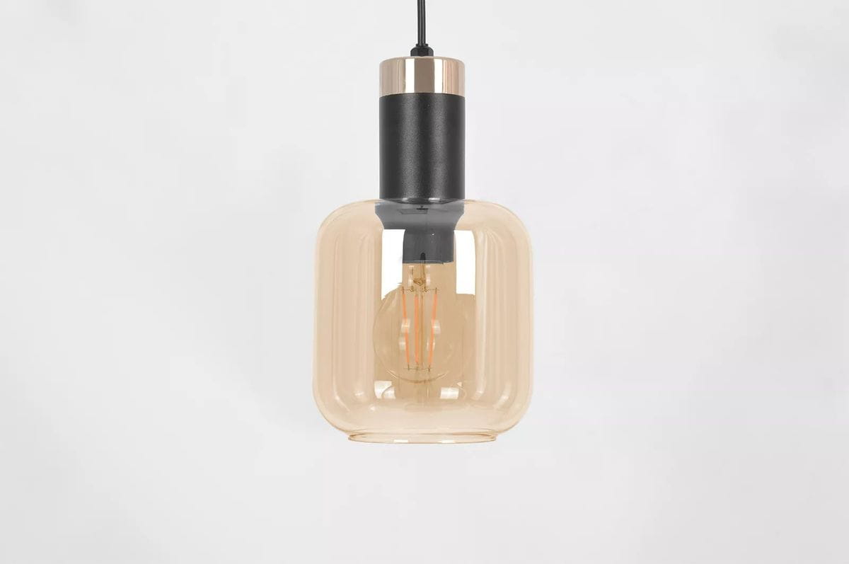 Lampa wisząca Doka 3xE27 w kolorze czarnym i bursztynowym. Szklany klosz o prostokątnym kształcie z widoczną żarówką. Metalowe wykończenie w górnej części. Produkt zawieszony na cienkim kabelku, na jednolitym tle.