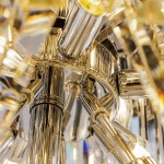 Luxe żyrandol w chromowanej obudowie, z widocznymi elementami szklanymi i żarówkami E14. Ujęcie z dołu, ukazujące szczegóły konstrukcji oraz refleksy świetlne. Złożony, elegancki design, idealny do nowoczesnych wnętrz.