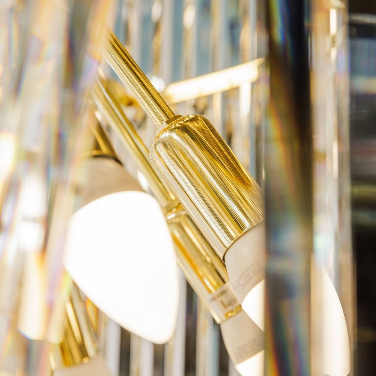 Luxe żyrandol 40xE14 w kolorze złotym, widok zbliżeniowy na detale konstrukcji. Widać eleganckie metalowe wykończenia i oprawy lamp, które otaczają białe klosze, tworząc stylowy element oświetleniowy.