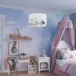 Lampa wisząca Koty 30 w białym kolorze, z kloszem z grafiką przedstawiającą różne koty. Zawieszona w pokoju dziecięcym, na tle pastelowej ściany z chmurkami. Wysoka, okrągła forma z czarną krawędzią, z jednym gniazdem E27.