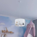Lampa wisząca Koty 30, 1xE27, z białym abażurem, na którym widoczne są ilustracje czterech kotów. Zawieszona na cienkim kablu, w pokoju dziecięcym, na tle pastelowej ściany z chmurkami i elementami dekoracyjnymi.