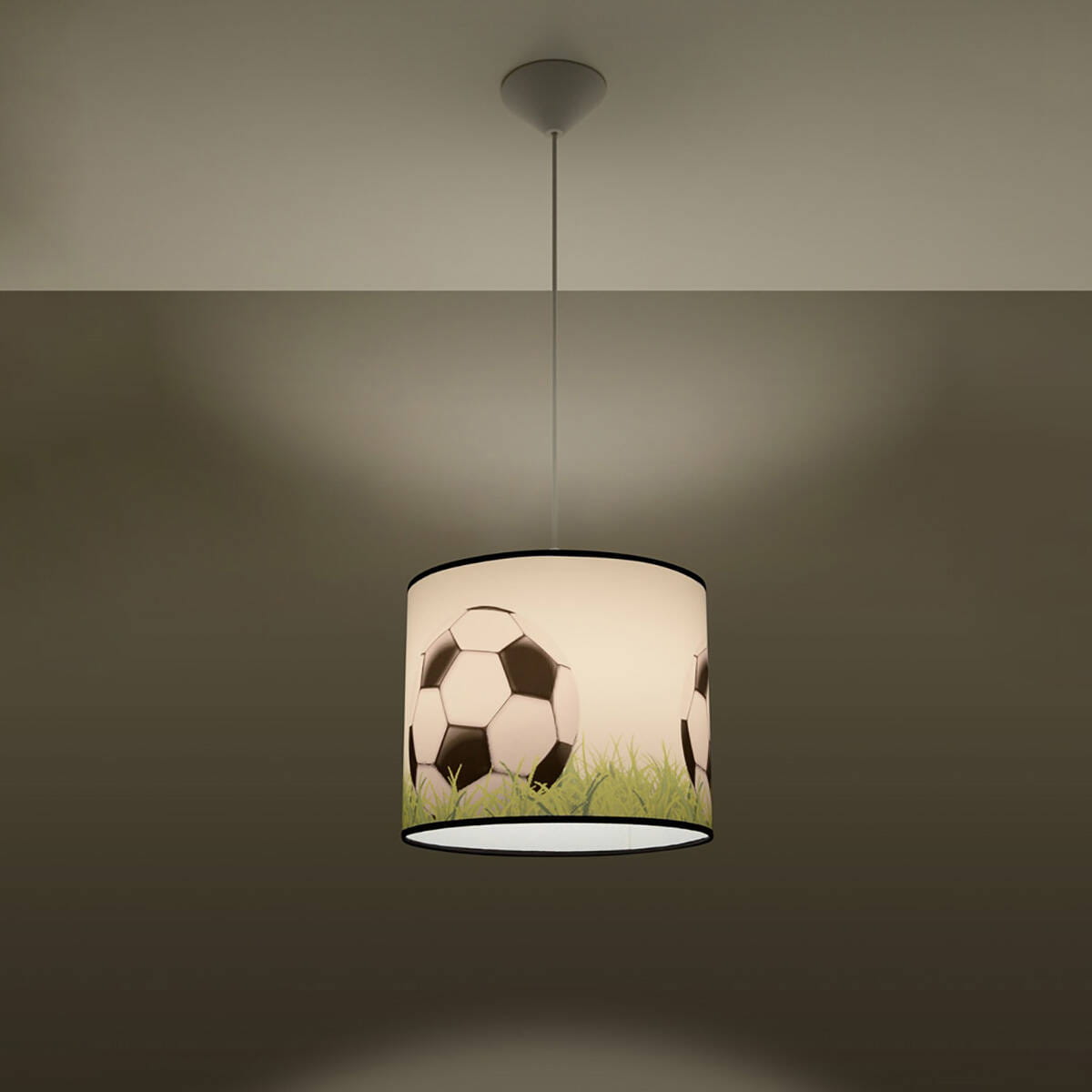 Lampa wisząca w kształcie cylindrycznym, z wzorem piłek nożnych na białym tle, z zielonymi elementami trawy. Zawieszona na cienkim przewodzie, z mocowaniem sufitowym. Wymaga żarówki E27.