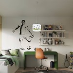 Lampa wisząca Piłka 30 w kolorze białym z oprawą na żarówkę E27. Ujęcie frontalne, zawieszona nad biurkiem w pokoju dziecięcym. W tle grafika piłkarza oraz regał z zabawkami. Proste tło, które podkreśla design lampy.