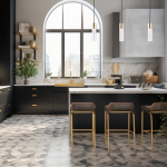 Lampa wisząca Ricky w kolorze czarnym i złotym, z miejscem na jedną żarówkę GU10. Zawieszona w nowoczesnej kuchni, obok okna, z minimalistycznym designem i szklanym kloszem. W tle widoczne eleganckie meble oraz stół z krzesłami.