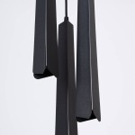 Lampa wisząca Prysm 3P w kolorze czarnym z trzema źródłami światła G9. Składa się z trzech smukłych, prostopadłościennych elementów z matowego materiału, zawieszonych na czarnym kablu. Tło białe, co podkreśla wygląd lampy.