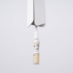 Lampa wisząca Prysm w kolorze białym, zawieszona na cienkim przewodzie. Wyposażona w gniazdo G9 dla żarówki LED (maks. 8W), z widoczną żarówką z diodami LED. Prosty, nowoczesny design z minimalistycznym wykończeniem.