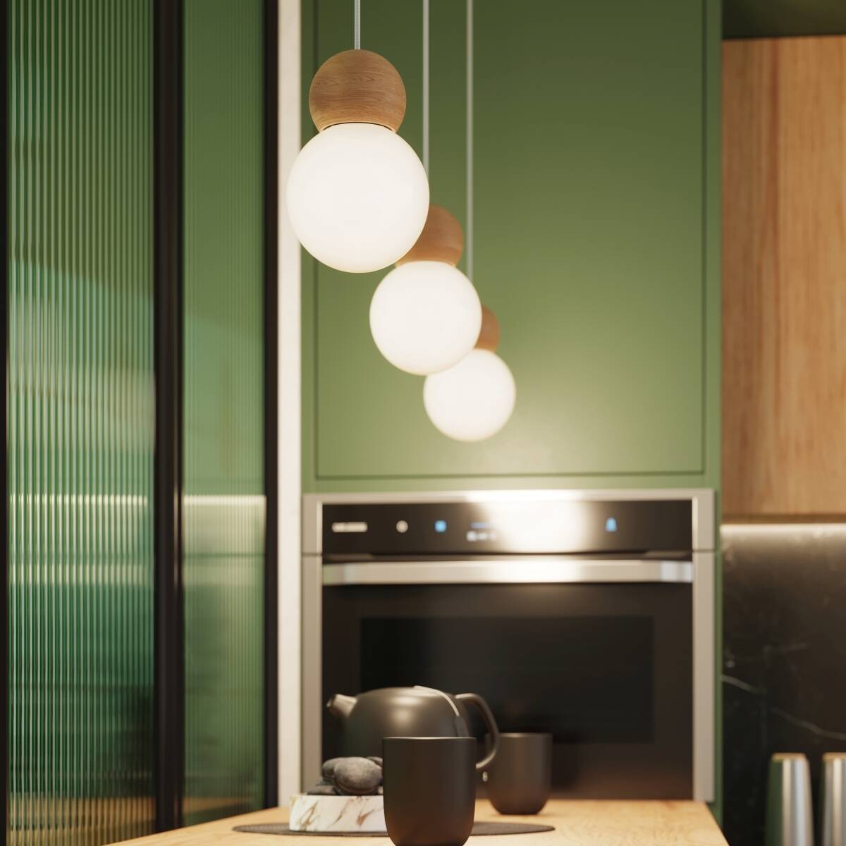 Lampa wisząca Pekka 1xG9 z drewnianym elementem, w kształcie okrągłej, białej kulki. Zawieszona w kuchni nad drewnianym blatem, w towarzystwie czarnego czajnika i filiżanek. Tło w odcieniach zieleni i drewna, tworzy nowoczesną aranżację.
