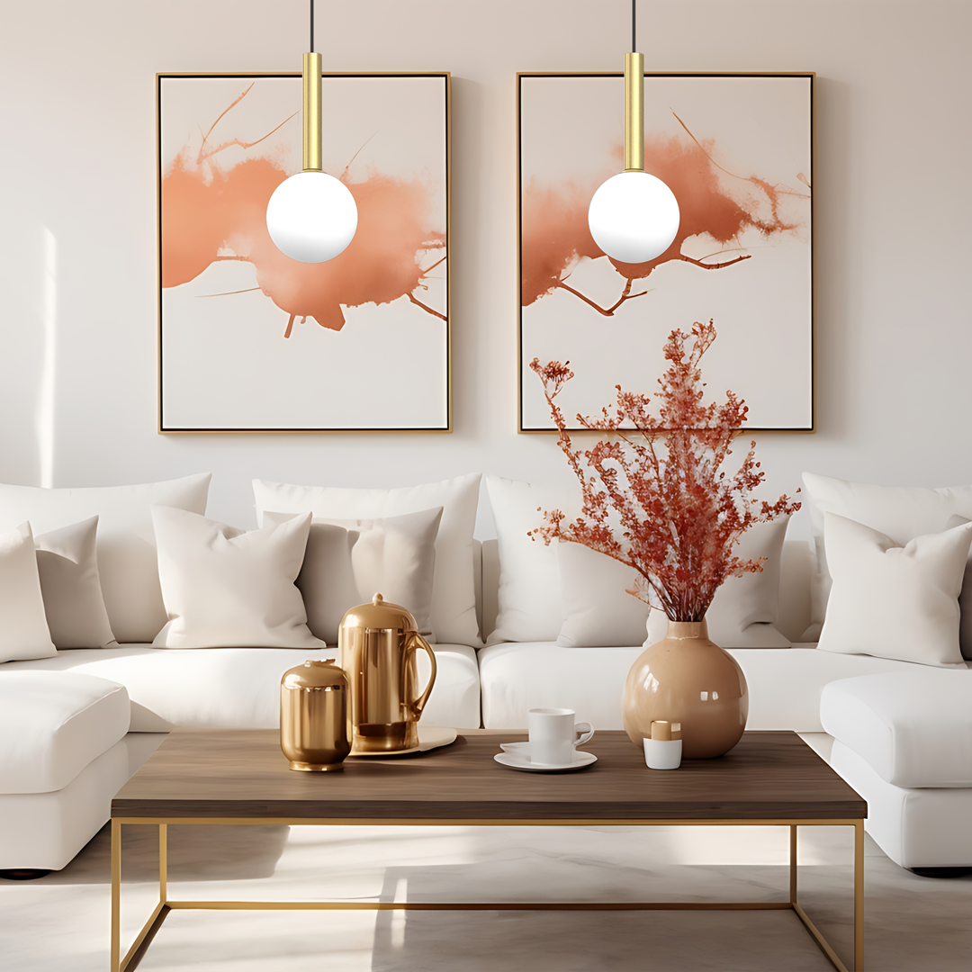 Lampa wisząca Play z jednym źródłem światła G9 w kolorze czarnym i złotym, zawieszona na cienkim kablu. W tle białe ściany z abstrakcyjnymi obrazami, eleganckie meble w stylu nowoczesnym oraz dekoracyjne akcesoria w odcieniach złota.