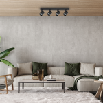 Czarna lampa sufitowa Volf z czterema spotami GU10, zamontowana na drewnianym suficie. W tle nowoczesny salon z jasną sofą i zielonymi poduszkami, stół z dekoracjami i rośliną. Oświetlenie skierowane na strefę wypoczynkową.