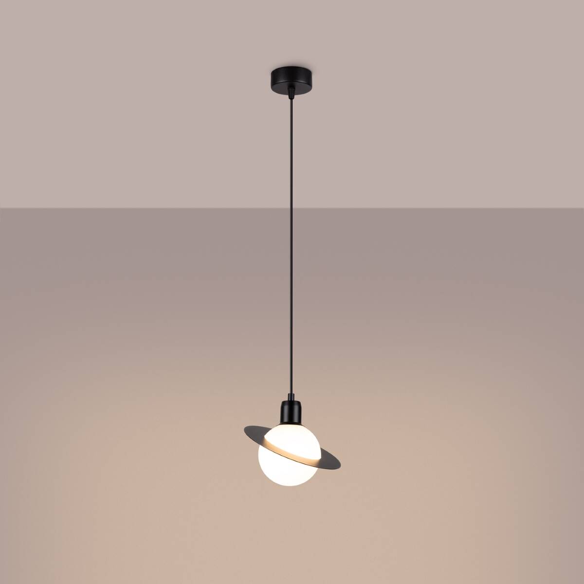 Czarna lampa wisząca Hyperion z jednym gniazdem G9, zawieszona na cienkim przewodzie. Okrągła, matowa kula ze szkła otoczona płaskim, czarnym pierścieniem. Prosty design, idealna do nowoczesnych wnętrz, na tle delikatnego, jednolitego koloru ściany.
