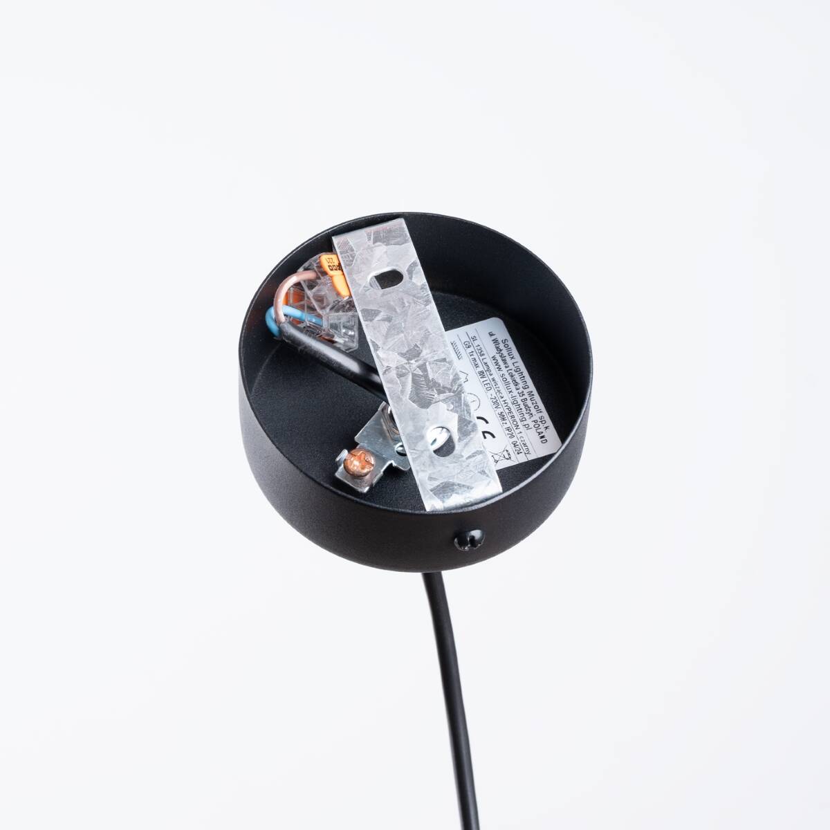 Czarna lampa wisząca Hyperion z gniazdem G9. Widok od góry, ukazujący okrągłą podstawę z przewodami i metalowym mocowaniem. Tło białe, co podkreśla szczegóły konstrukcji.