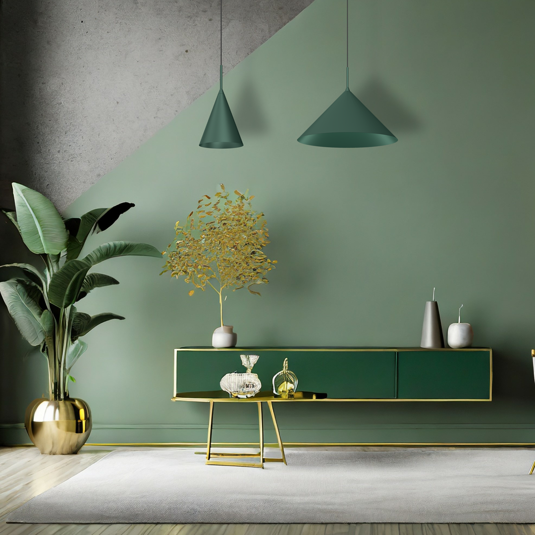 Lampa wisząca Capital D17 w butelkowej zieleni, zawieszona w nowoczesnym wnętrzu. Kształt stożkowaty, z jedną oprawą GX53. W tle zielona ściana, meble w odcieniach zieleni i złota, rośliny dekoracyjne.