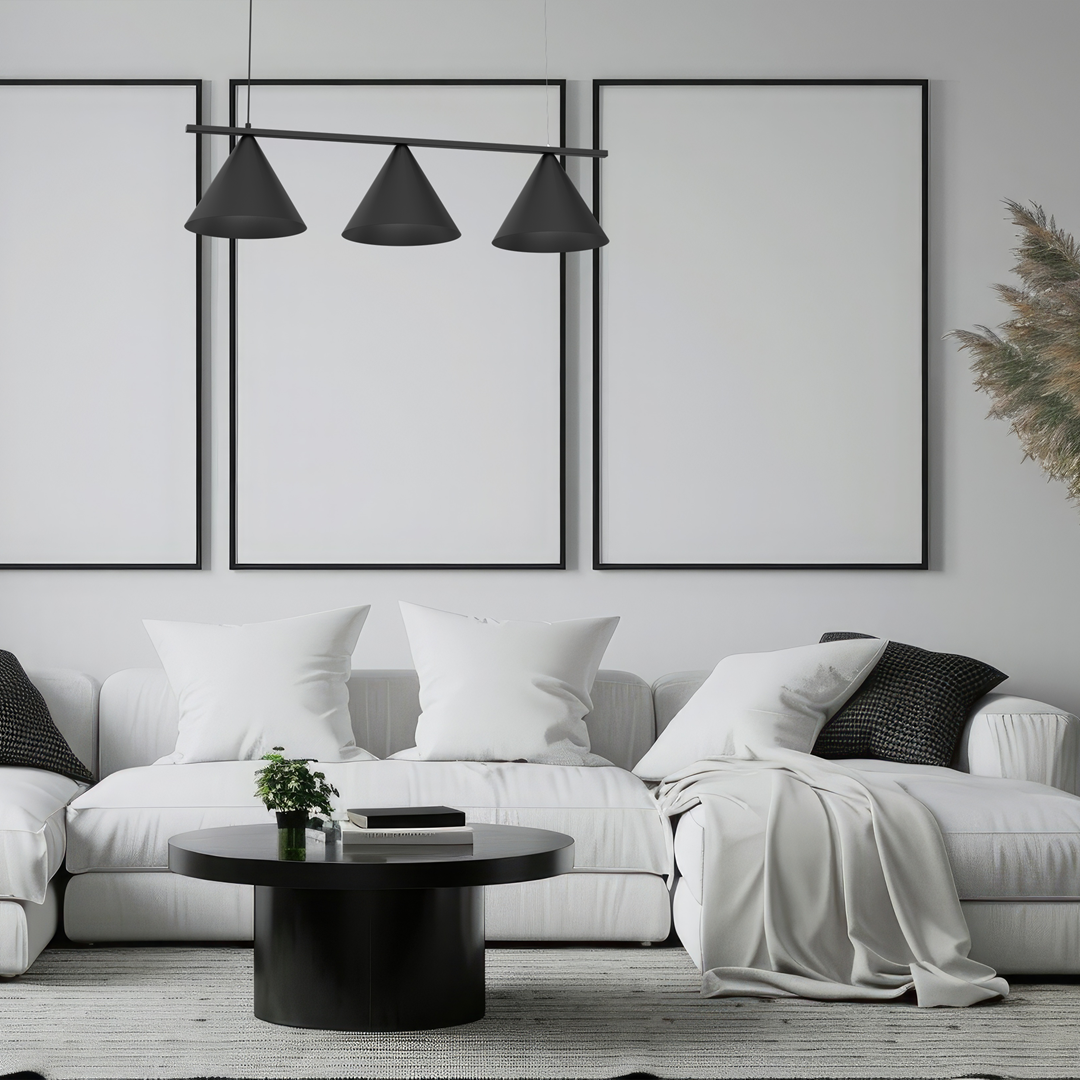 Lampa wisząca Capital w kolorze czarnym z trzema stożkowymi kloszami, zawieszona nad okrągłym stołem w nowoczesnym wnętrzu. Klosze są matowe, a lampa umieszczona w minimalistycznym pomieszczeniu z białą sofą i dekoracjami.