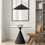Lampa wisząca Capital D60 w kolorze czarnym, z metalowym kloszem w kształcie stożka, zawieszona nad okrągłym stołem z marmurowym blatem. W tle widoczna drewniana półka z książkami oraz krzesło o geometrycznym kształcie.