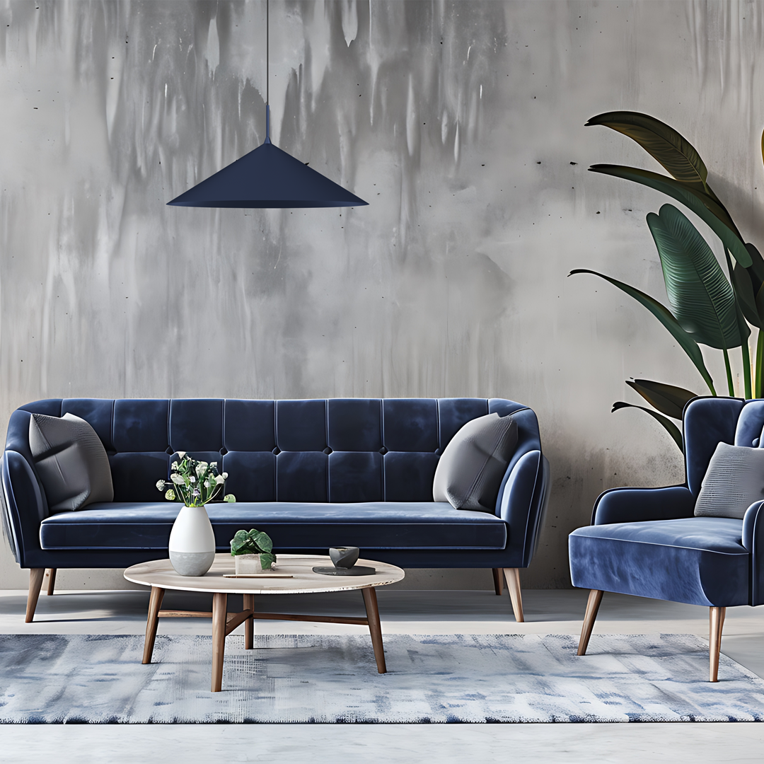 Granatowa lampa wisząca Capital D60 z jednym gniazdem GX53, o stożkowym kształcie, zawieszona nad jasnym, nowoczesnym stołem kawowym. W tle widoczna elegancka sofa w odcieniach niebieskiego i rośliny, na szaro-białej ścianie.