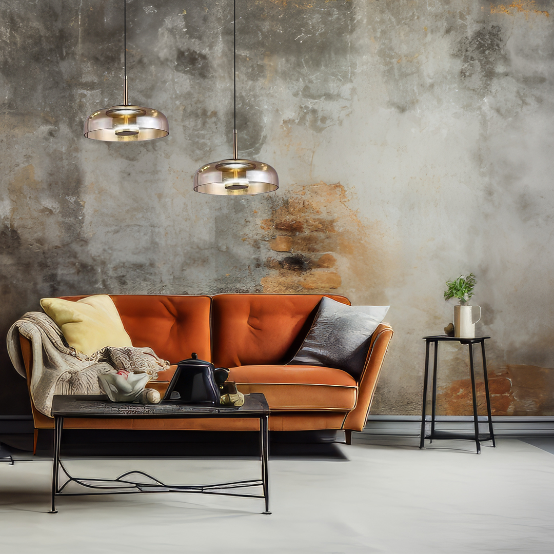 Lampa wisząca Vetro 1xLED/6W w kolorze czarnym z bursztynowym kloszem, zawieszona na cienkim kabelku, w aranżacji z pomarańczową sofą, na tle surowej, zniszczonej ściany. Idealna do nowoczesnych wnętrz.