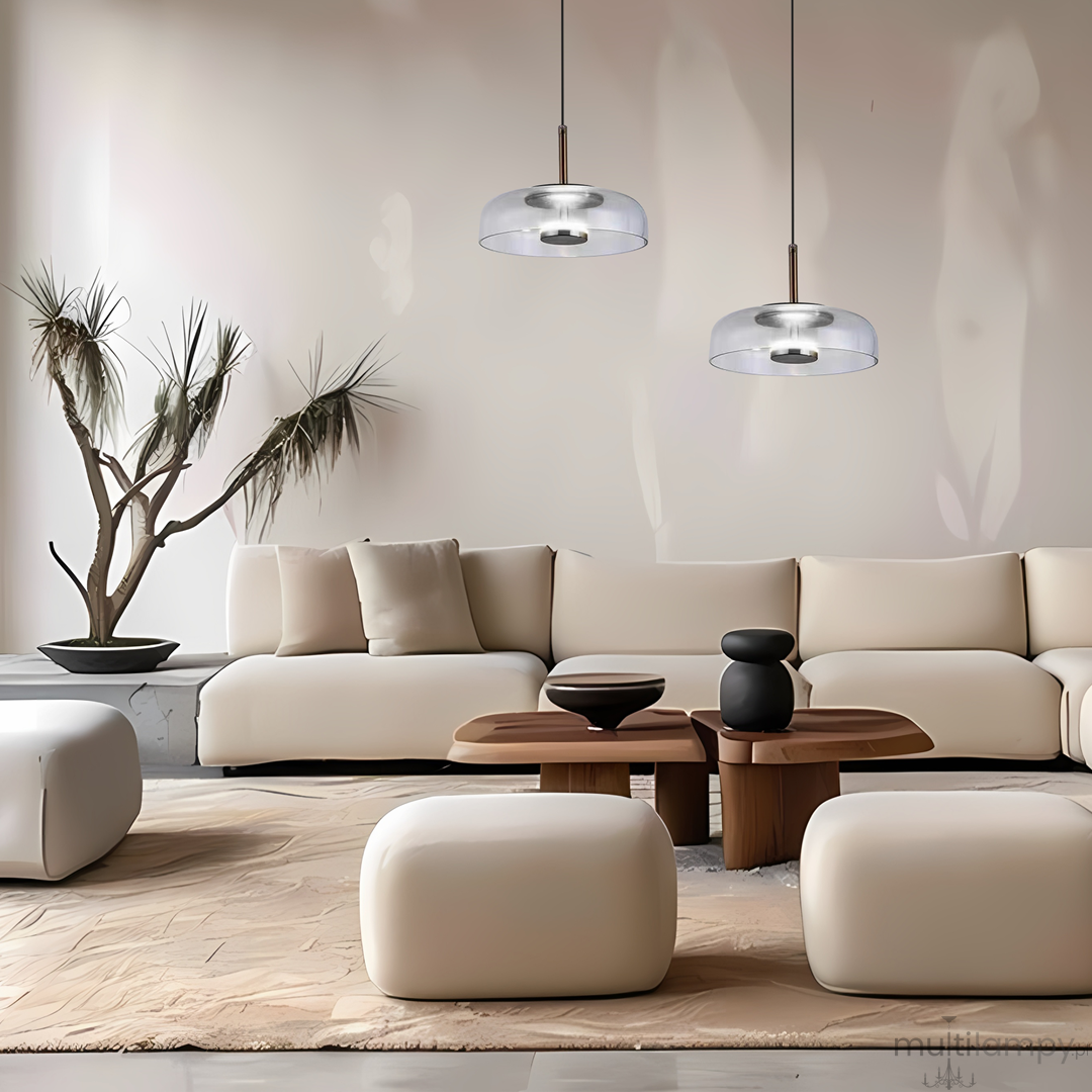 Lampa wisząca Vetro w kolorze czarnym z przezroczystym kloszem, zawieszona na cienkim przewodzie. Oświetlenie LED 6W, nowoczesny design, umieszczona nad drewnianym stolikiem w minimalistycznym wnętrzu z jasnymi meblami.