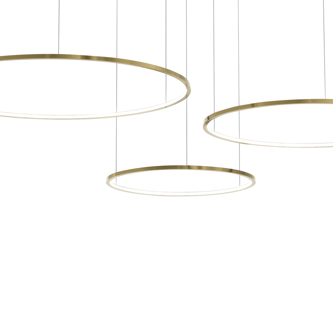 Lampa wisząca Saturno z trzema okrągłymi ramami w kolorze złotym, wykonana z metalu, z wbudowanym oświetleniem LED. Elementy zawieszone na cienkich żyłkach, umiejscowione na białym tle.