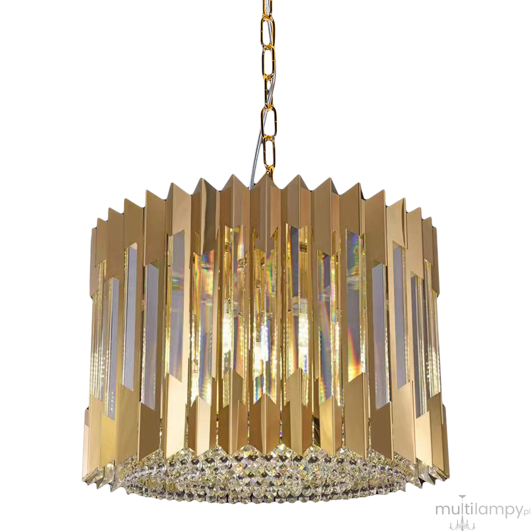 Lampa wisząca Ritz 7xE14 w złotym kolorze, o cylindrycznym kształcie, z metalowymi, lustrzanymi panelami i kryształowymi detalami na dolnej krawędzi. Zawieszona na złotym łańcuszku, idealna do nowoczesnych wnętrz.