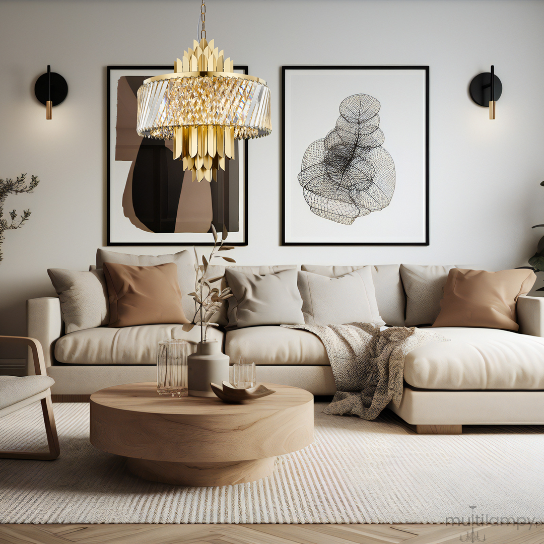 Lampa wisząca Margot w kolorze złotym, z kloszem z przezroczystych kryształów i dekoracyjnymi złotymi elementami. Zawieszona w centralnej części nowoczesnego wnętrza, nad okrągłym drewnianym stolikiem z roślinnością.