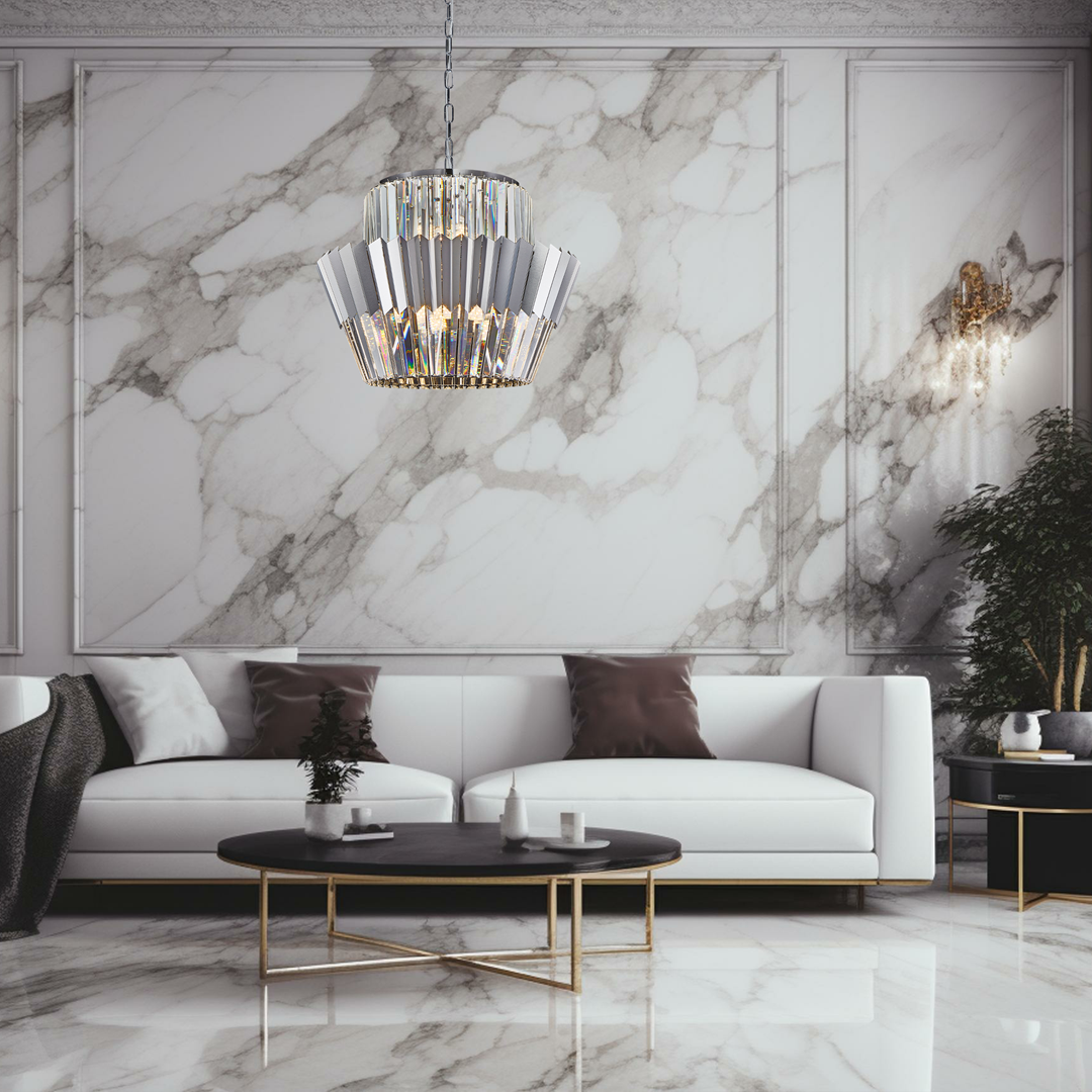 Lampa wisząca Donna z 12 gwintami E14, w chromowanej obudowie o geometrycznym kształcie. Zawieszona na cienkim łańcuchu, umieszczona w nowoczesnym wnętrzu z białą sofą i marmurową ścianą. Elegancki detal w aranżacji.