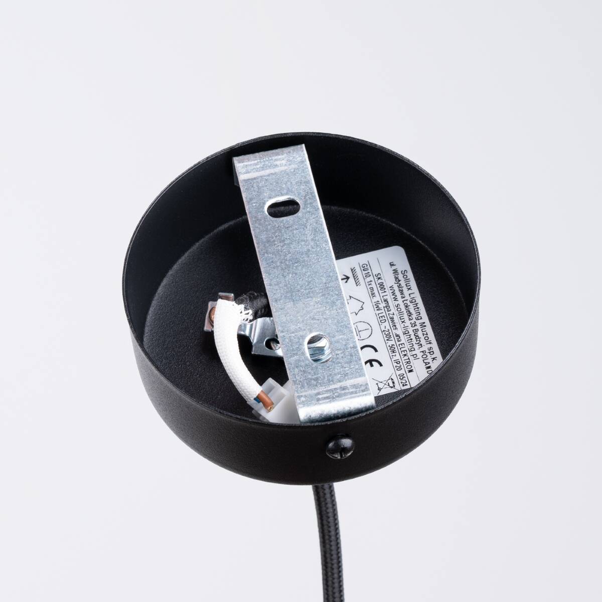 Lampa wisząca Electra w czarnej ceramice z miejscem na jedną żarówkę GU10. Widok z góry, ukazujący metalowy uchwyt mocujący oraz wnętrze oprawy. Tło białe, co podkreśla detale produktu.