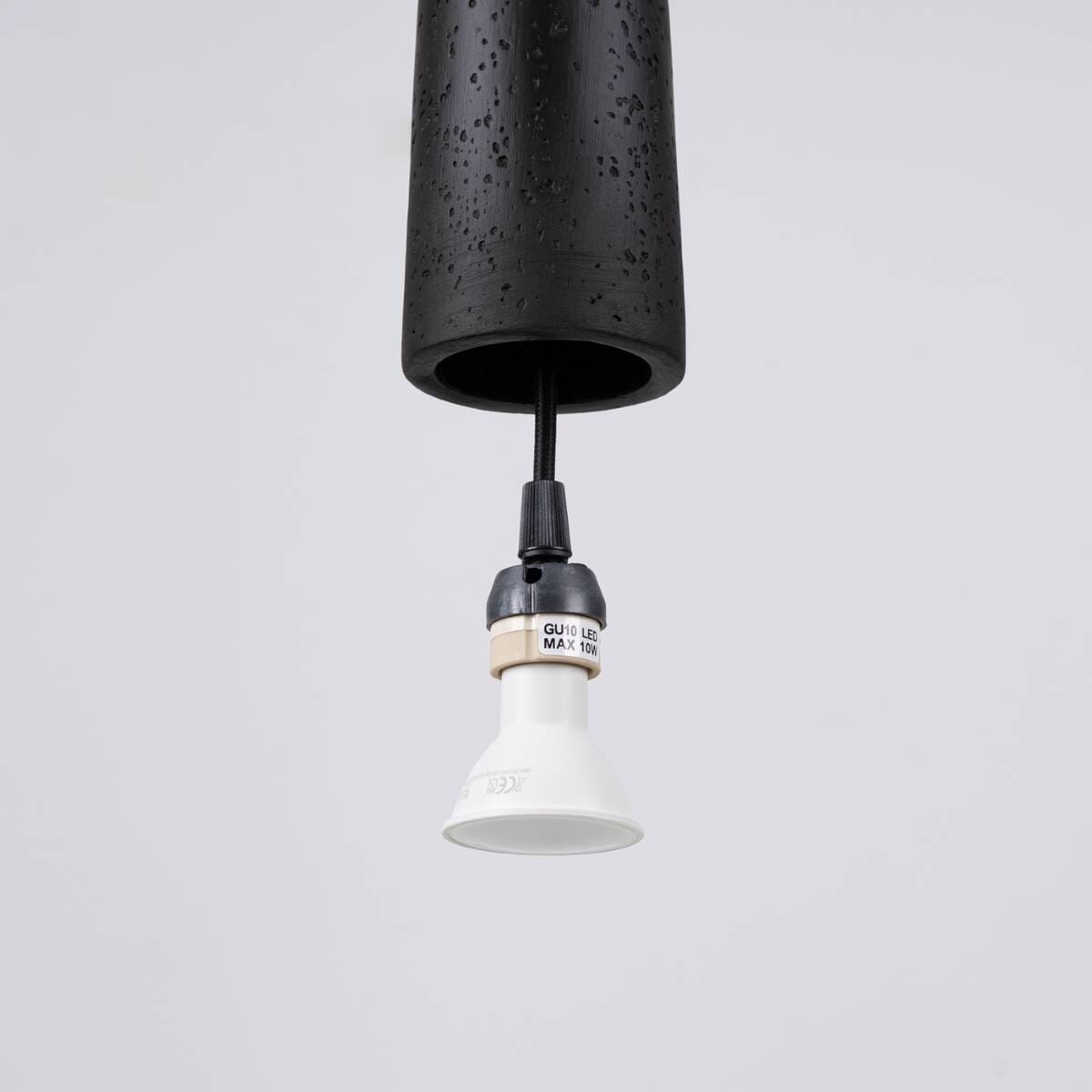 Lampa wisząca Electra w czarnym ceramicznym wykończeniu, z gniazdem GU10, zawieszona na czarnym przewodzie. Widoczny detal białej oprawki z oznaczeniem maksymalnej mocy 10W. Prosta konstrukcja, idealna do nowoczesnych wnętrz.