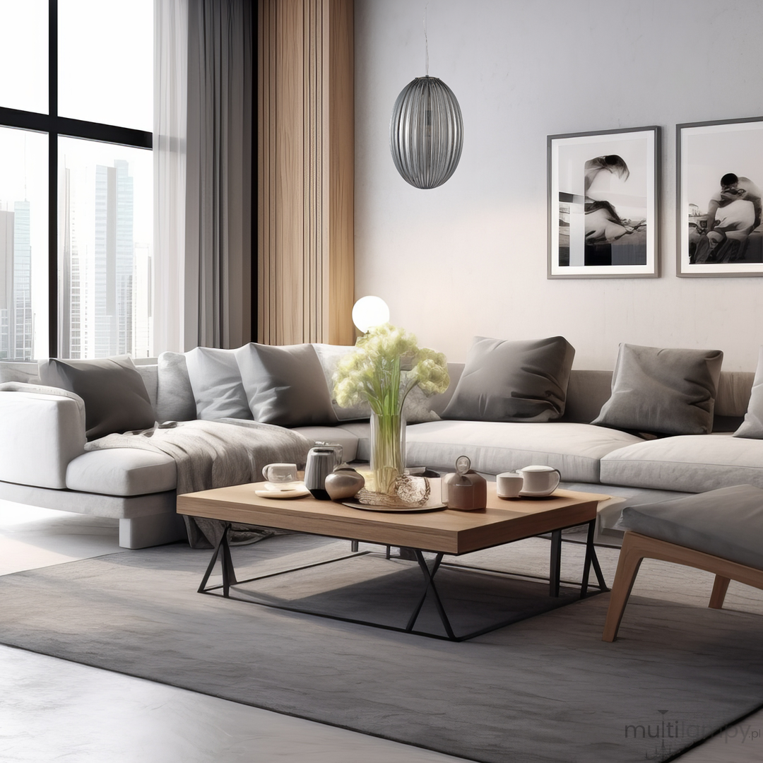 Lampa wisząca Braga 1xE27 w chromowanym wykończeniu, o dymionym kloszu w kształcie elipsy, zawieszona w nowoczesnym wnętrzu z szarym narożnikiem i drewnianym stolikiem kawowym. Tło z dużymi oknami oraz minimalistycznymi dekoracjami.