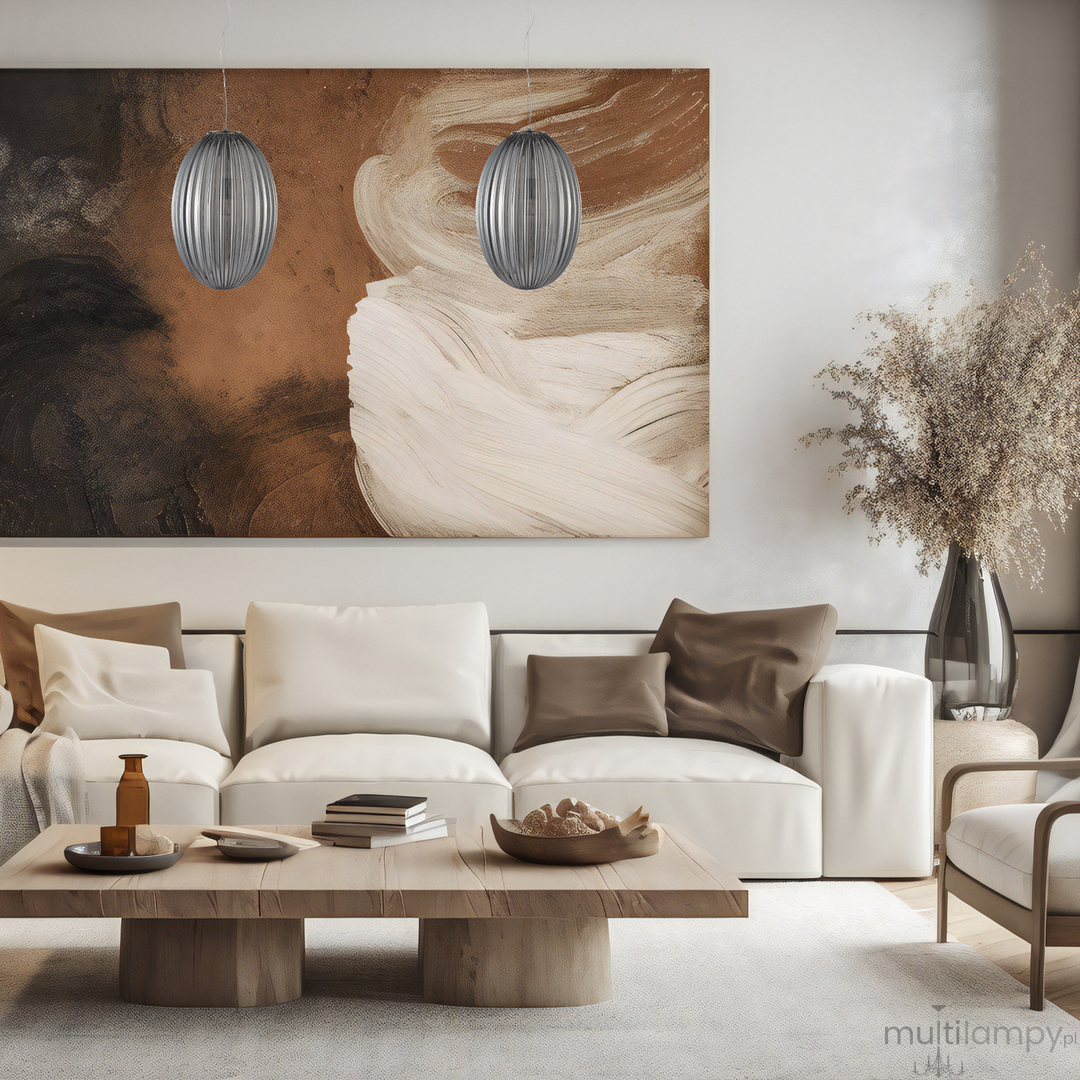 Lampa wisząca Braga 1xE27 w chromowanej obudowie z dymionym kloszem, umieszczona w nowoczesnym wnętrzu. Produkt zawieszony nad stołem, w tle obraz z abstrakcyjnym motywem w odcieniach brązu i beżu.