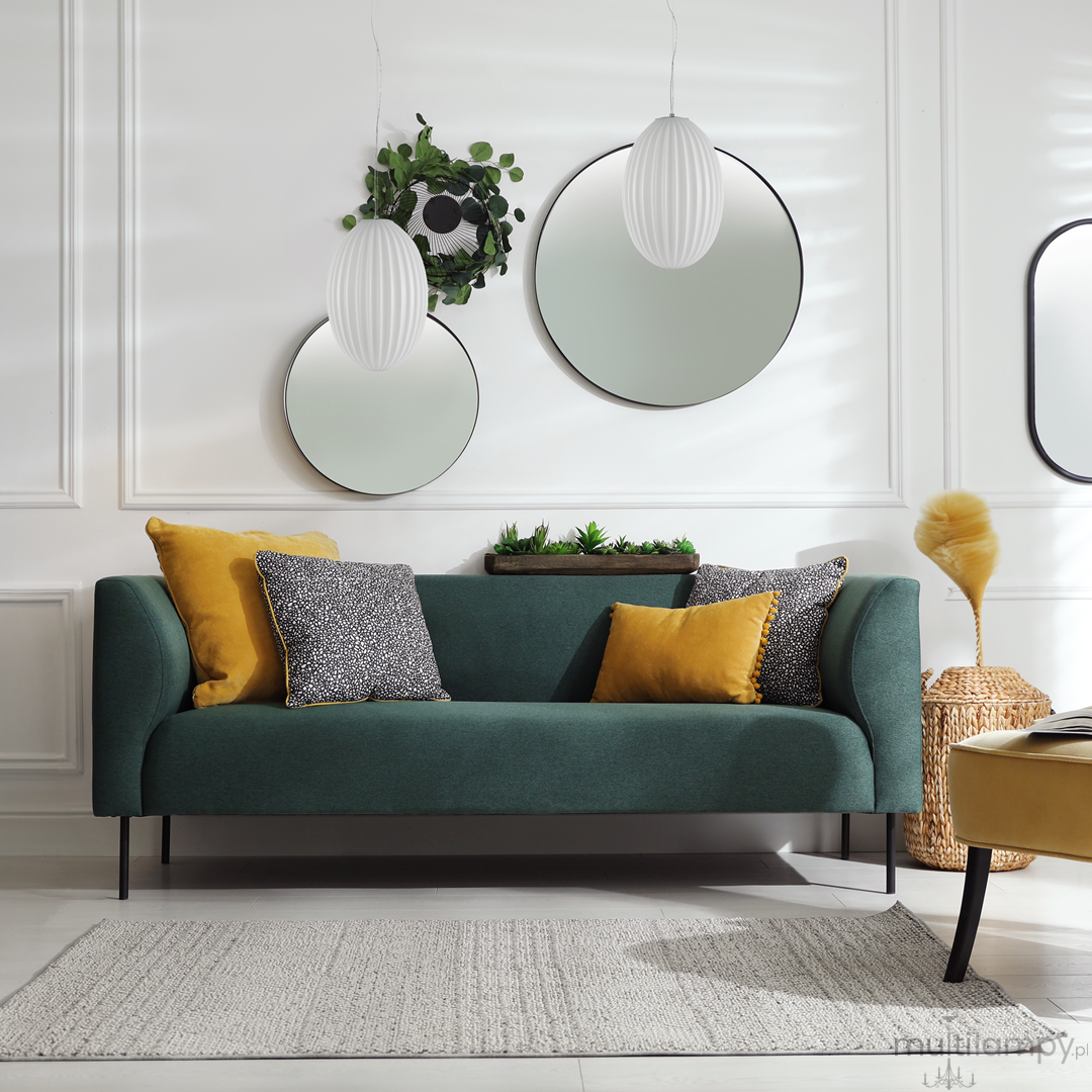 Lampa wisząca Braga 1xE27 w kolorze chromu i białym, z okrągłym kształtem. Zawieszona nad zieloną sofą z poduszkami w odcieniach żółtego i czarno-białym wzorem. Tło jasne, z lustrami i roślinami, tworzy nowoczesną aranżację wnętrza.