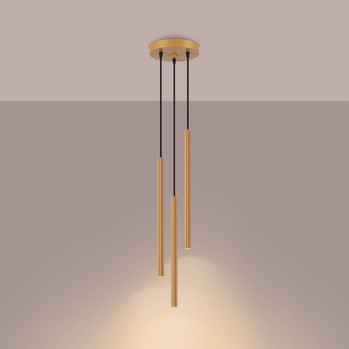 Lampa wisząca Arche z trzema złotymi, cylindrycznymi kloszami na czarnych przewodach. Klasyczna konstrukcja montowana sufitowo, idealna do nowoczesnych wnętrz. Klosze mają teksturowaną powierzchnię, emitując ciepłe światło. Tło w jasnym odcieniu.