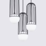 Lampa wisząca Brina 3P w kolorze czarnym z trzema kloszami w formie białych kul, osłoniętymi metalową klatką. Ujęcie z góry, prezentujące zawieszenie i detale konstrukcyjne. Idealna do nowoczesnych wnętrz.
