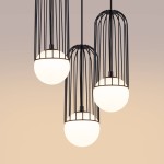 Lampa wisząca Brina 3P z trzema kloszami w kształcie kul, osłoniętymi czarną metalową siatką. Wisi na cienkich kablach, z białymi, szklanymi kulami emitującymi światło. Tło w odcieniach beżu, podkreślające elegancję lampy.