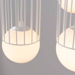 Lampa wisząca Brina 3P w białej kolorystyce z trzema okrągłymi, mlecznymi kloszami zamkniętymi w metalowej, białej klatce. Produkt wisi na białym kablu, z widoczną oprawą G9. Ujęcie zbliżeniowe na detale lampy.