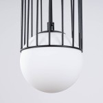 Czarna lampa wisząca Brina z kloszem w kształcie kuli, wykonana z matowego szkła, umieszczona w metalowej siatce. Ujęcie z góry, ukazujące szczegóły konstrukcji oraz połączenie klosza z zawieszeniem.