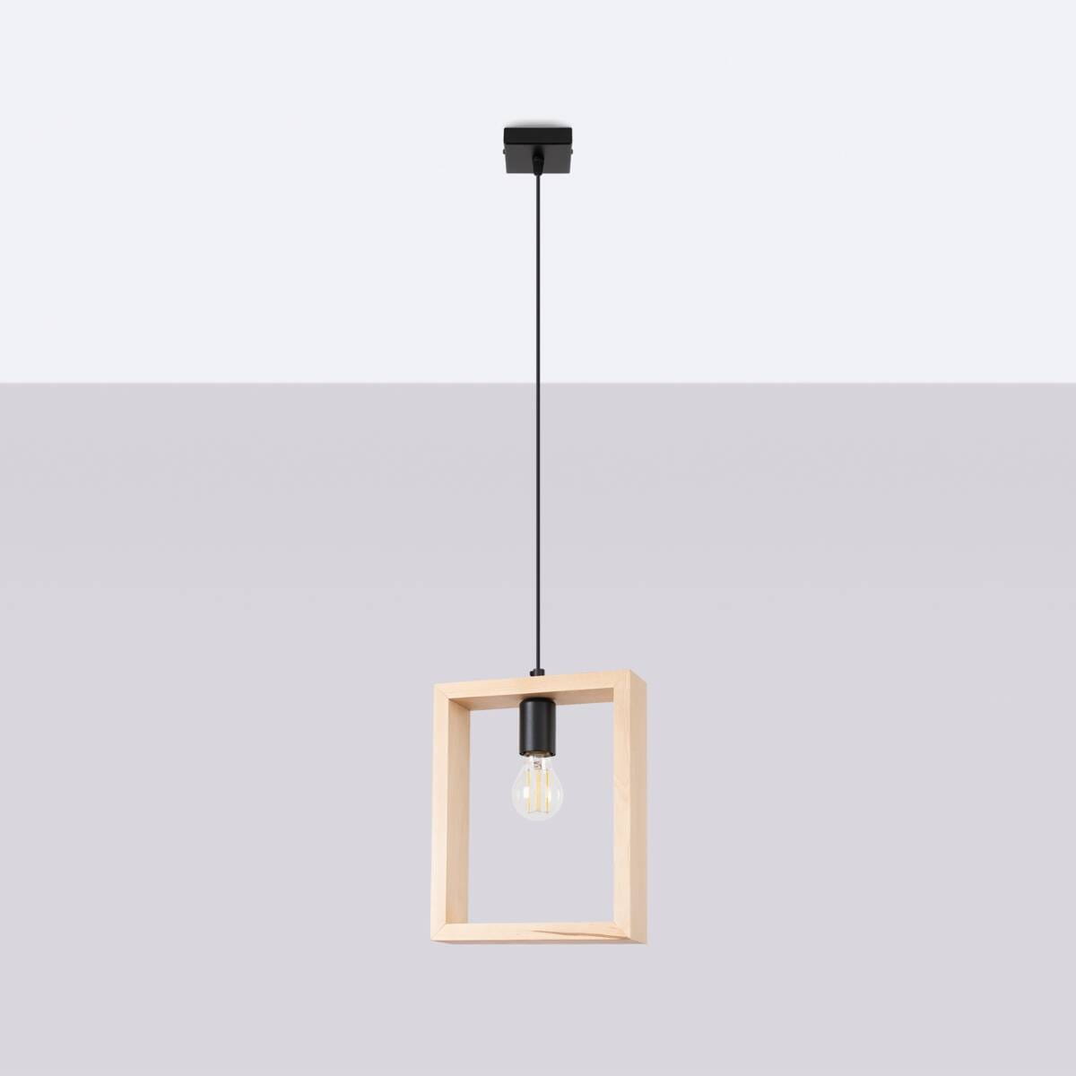 Lampa wisząca Aries 1xE27 w kolorze czarnym i naturalnym drewnie. Posiada prostokątną ramę z drewna z czarnym uchwytem na żarówkę. Zawieszona na cienkim, czarnym przewodzie. Tło jasnoszare, podkreślające minimalistyczny design.