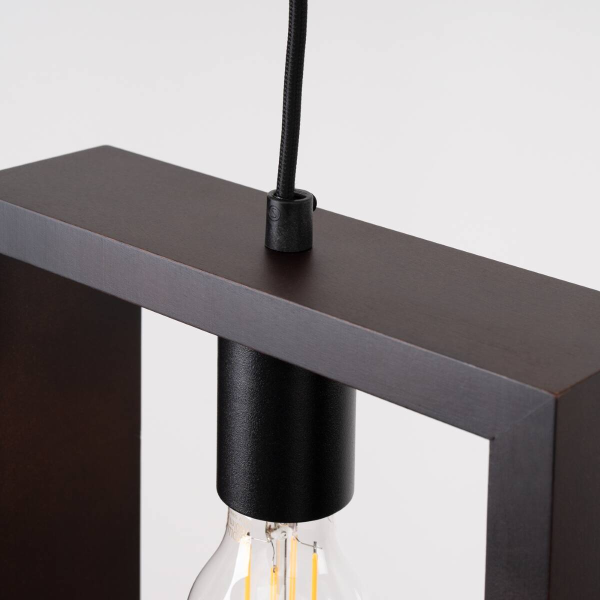 Lampa wisząca Aries w kolorze czarnym i wenge, z oprawą E27. Widoczny detal mocowania oraz przewód zasilający. Kąt ujęcia z góry, ukazujący górną część lampy i żarówkę.
