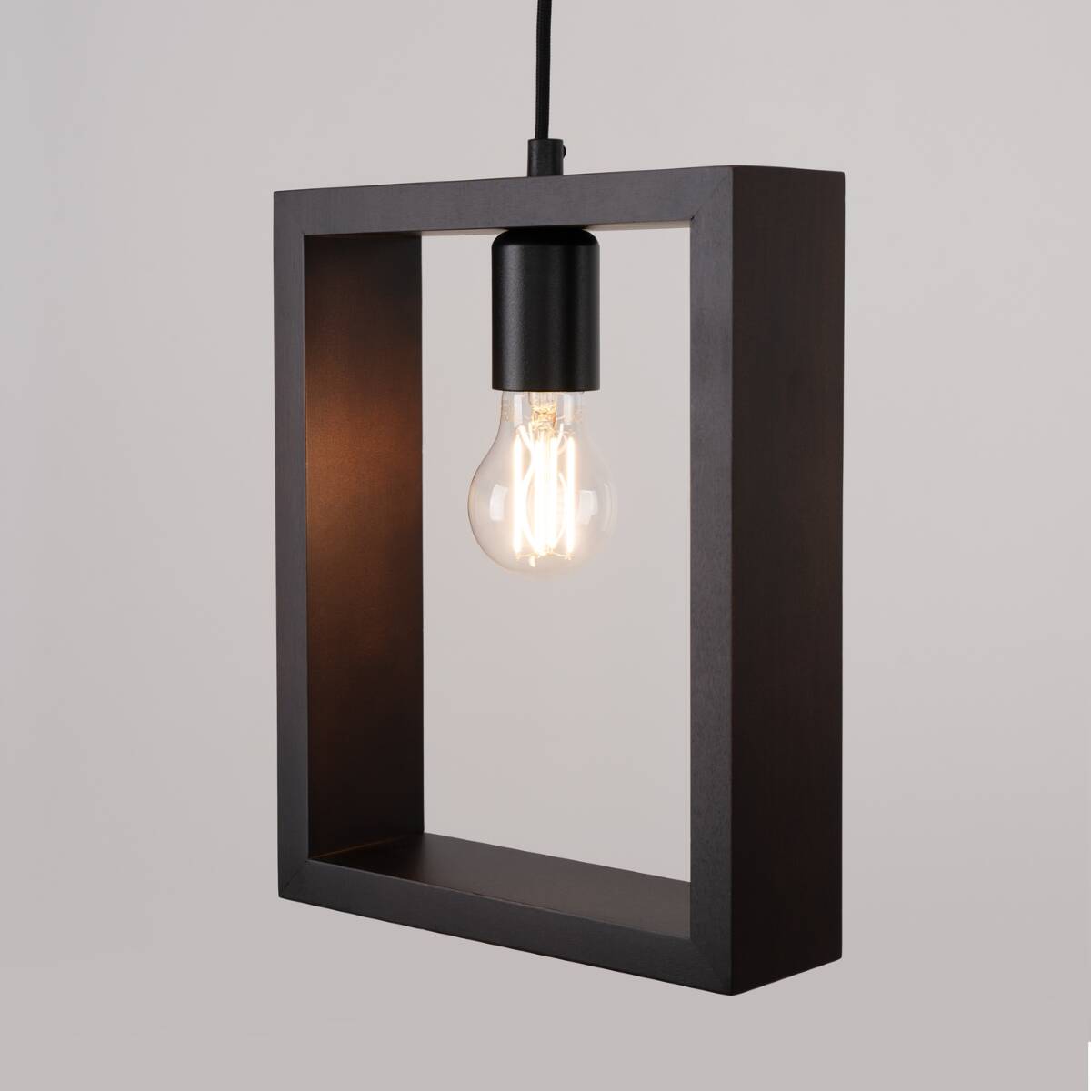 Lampa wisząca Aries 1xE27 w kolorze czarnym i wenge. Posiada prostokątną ramę z drewna wenge, z widoczną żarówką w przezroczystym kloszu. Ujęcie z przodu, wisi na czarnym przewodzie, na jednolitym tle.
