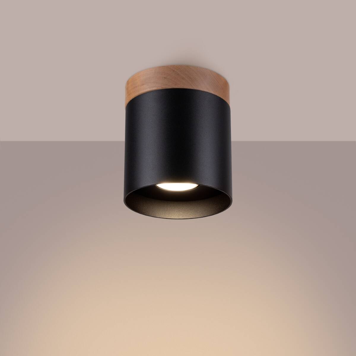 Lampa sufitowa Rif w formie czarnej tuby z drewnianym wykończeniem u góry. Montowana na suficie, z widoczną oprawą na żarówkę GU10. Minimalistyczny design, idealna do nowoczesnych wnętrz.