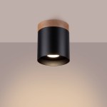Lampa sufitowa Rif w formie czarnej tuby z drewnianym wykończeniem u góry. Montowana na suficie, z widoczną oprawą na żarówkę GU10. Minimalistyczny design, idealna do nowoczesnych wnętrz.