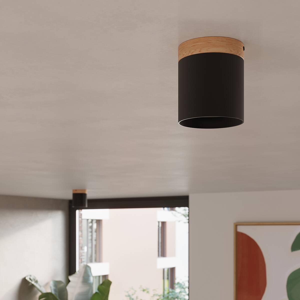 Lampa sufitowa Rif tuba 1xGU10 w kolorze czarnym z drewnianym wykończeniem. Zamontowana na suficie, okrągła forma z widocznym elementem drewnianym. Tło neutralne, minimalistyczne wnętrze z roślinnością.