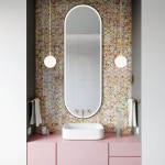 Lampa wisząca Paloma D12 z mosiężnym detalem i białym kloszem, zawieszona na długim przewodzie w łazience z kolorową, kwiatową tapetą. Produkt umieszczony obok prostokątnego lustra i umywalki na różowej szafce.