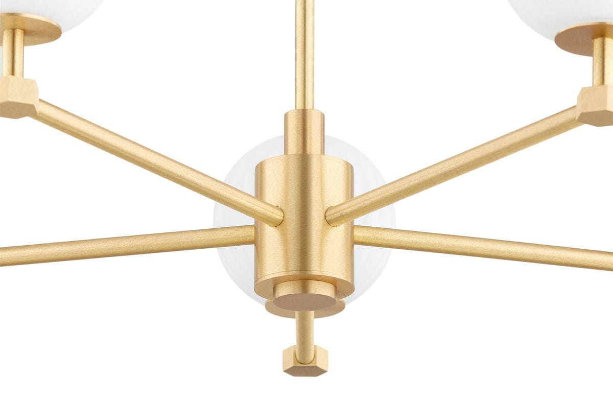 Mosiężny żyrandol Paloma z pięcioma ramionami na żarówki E14. W centralnej części widoczny metalowy stelaż w złotym kolorze, z białymi kloszami w kształcie kul. Produkt w pozycji wiszącej, z gładką fakturą. Idealny do nowoczesnych wnętrz.