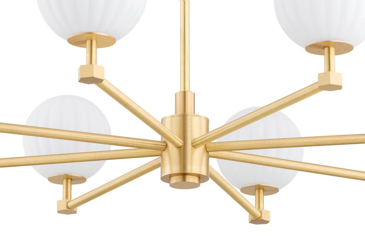 Żyrandol Paloma w kolorze mosiądzu z białymi kloszami, posiadający osiem ramion. Konstrukcja z metalowymi elementami ma nowoczesny design, a klosze mają delikatną, żłobkowaną fakturę. Ujęcie z dołu, ukazujące szczegóły mocowania i ramion.