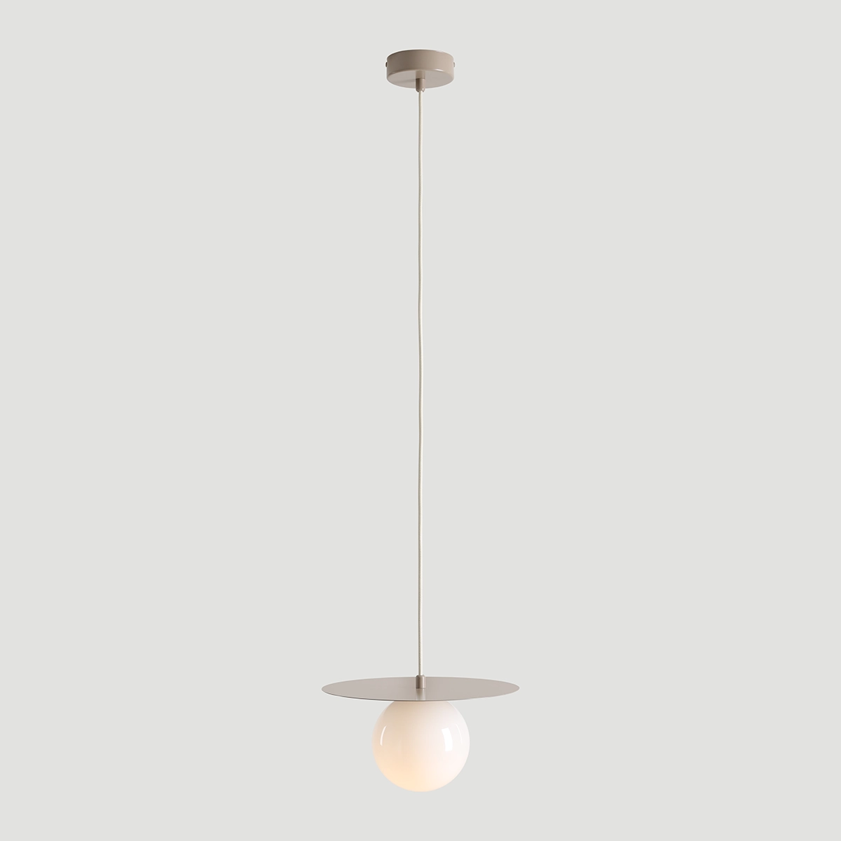 Lampa wisząca Loop Beige S z jednym gniazdem E14. Posiada okrągłą, mleczną kulę oraz płaski, okrągły klosz w kolorze beżowym. Zawieszona na cienkim, białym kablu z metalowym mocowaniem sufitowym. Prosty design, idealna do nowoczesnych wnętrz.