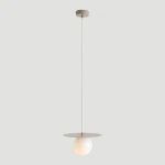 Lampa wisząca Loop Beige S z jednym gniazdem E14. Posiada okrągłą, mleczną kulę oraz płaski, okrągły klosz w kolorze beżowym. Zawieszona na cienkim, białym kablu z metalowym mocowaniem sufitowym. Prosty design, idealna do nowoczesnych wnętrz.