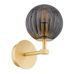 Kinkiet Paloma z mosiądzu w kolorze złotym, z dymną, szklaną kulą. Ułożony w pozycji stojącej, z okrągłą podstawą. Wewnątrz widoczna żarówka typu E14. Elegancki design z wyraźnymi żłobieniami na szkle.