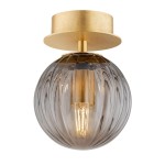 Kinkiet Paloma z mosiężnym wykończeniem i dymnym, szklanym kloszem w kształcie kuli. Ujęcie frontalne, z widoczną żarówką E14 wewnątrz. Gładka, lekko teksturowana powierzchnia klosza. Idealny do nowoczesnych wnętrz.